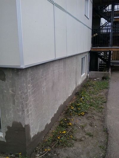 Concrete foundation before work: spalled and cracked surface.